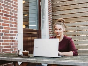 Ragazza seduta all'aperto davanti a un pc