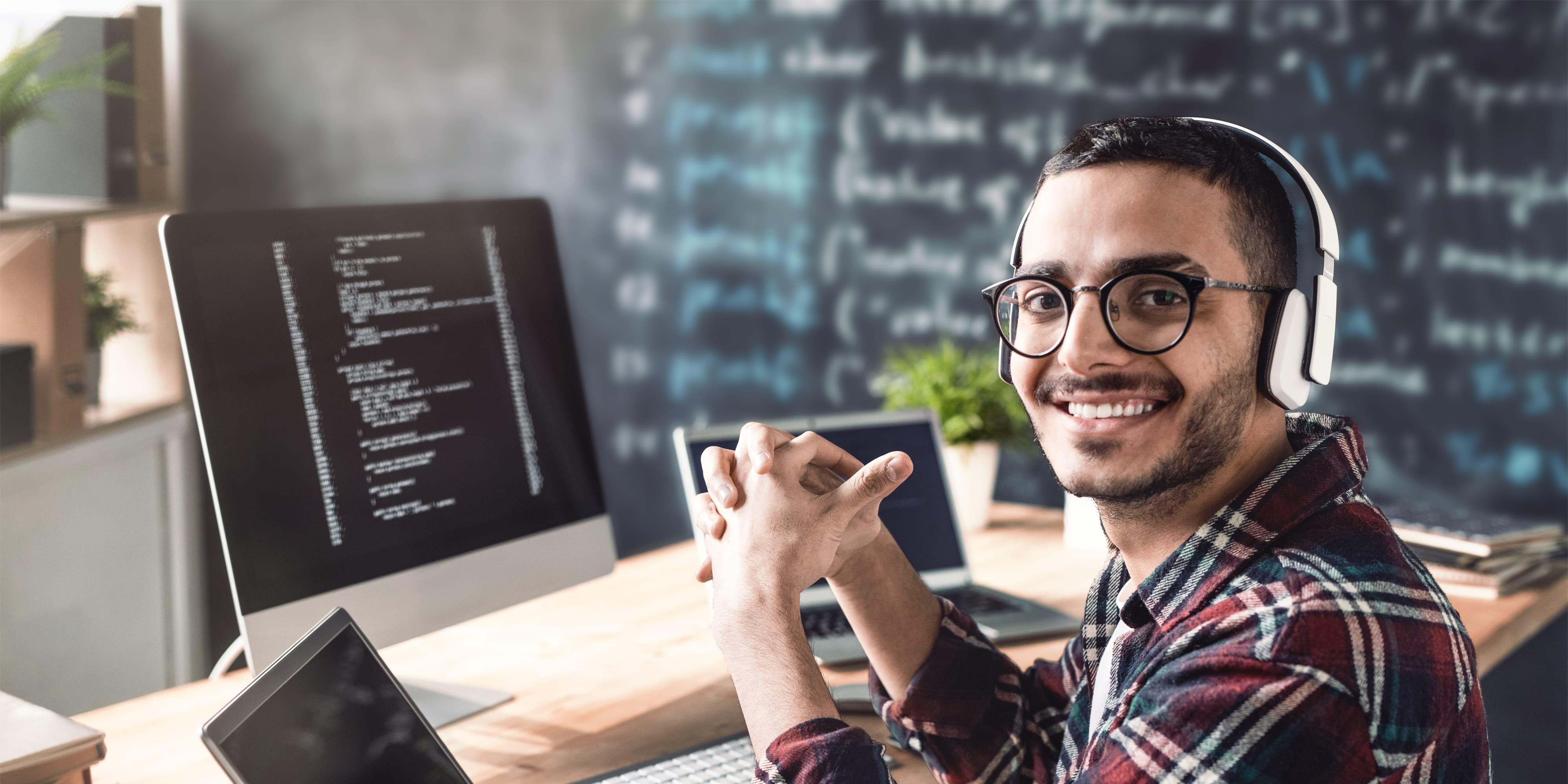 Titelbild für Infoseite “Bachelor Cyber Security”: Student mit Kopfhörer arbeitet am Laptop