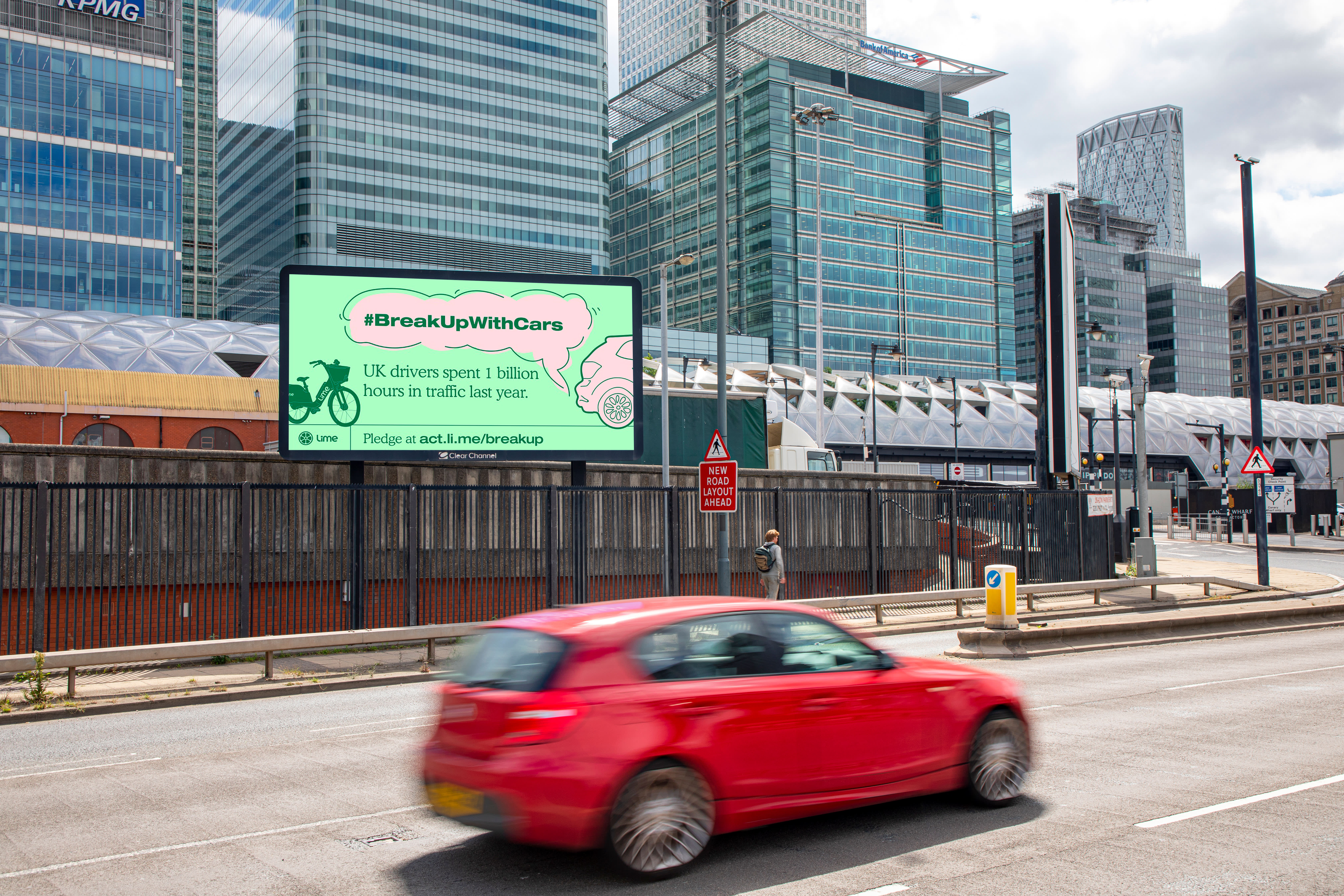 Billboard Live screen on a busy road showing Lime cycle ad